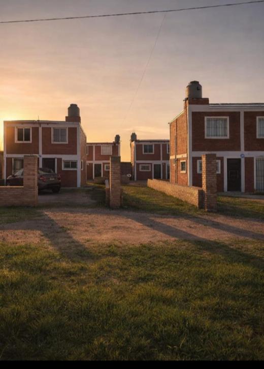 a group of buildings with the sun setting in the background at Dúplex para 4 San Luis in Barranca Colorada