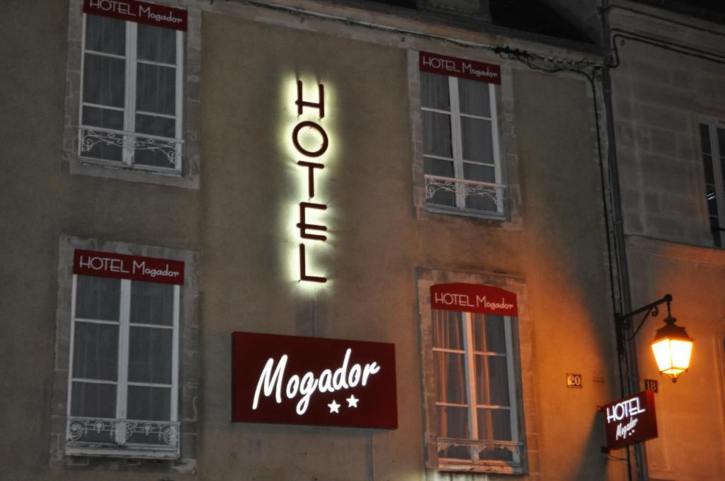 a neon sign on the side of a building at Le Mogador in Bayeux