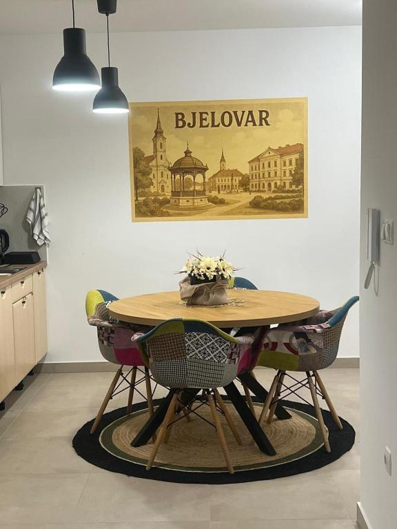 a dining room with a wooden table and chairs at BLANK apartman u centru in Bjelovar