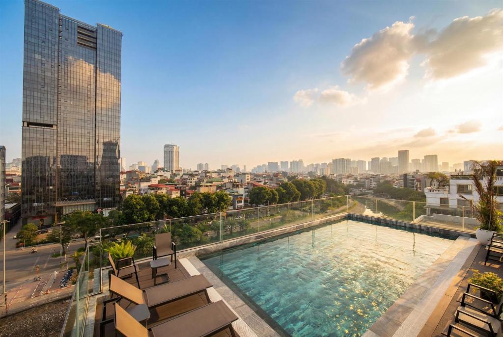 a swimming pool on the roof of a building with a city at GrandView Hotel & Residence Hanoi in Hanoi