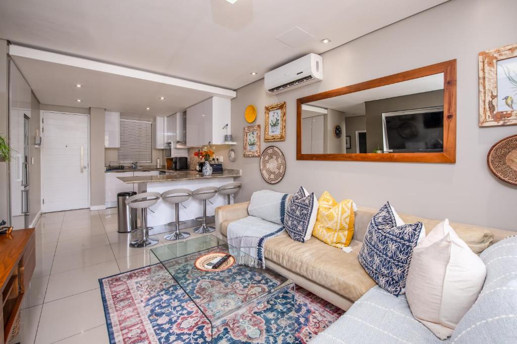 a living room with a couch and a kitchen at Instellies Andringa Walk Apartment in Stellenbosch