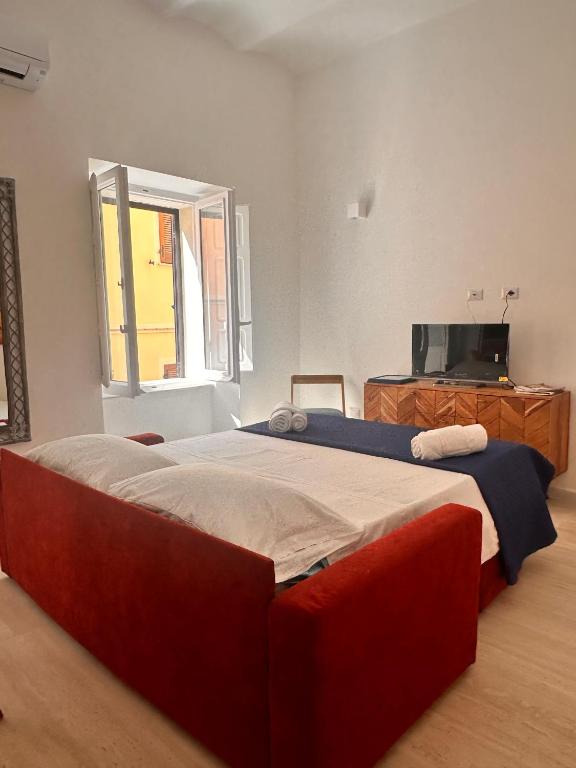 a bedroom with a large bed and a television at Vico Rosso - Milù Holidays La Maddalena in La Maddalena