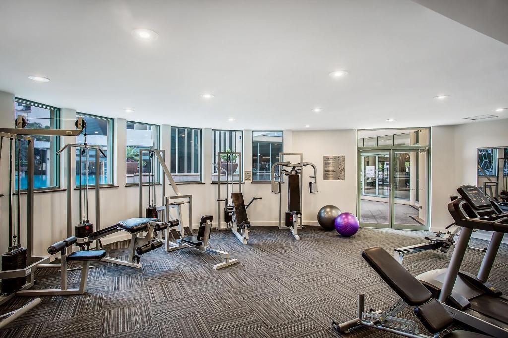 a gym with several treadmills and exercise machines at Mantra Legends Hotel in Gold Coast