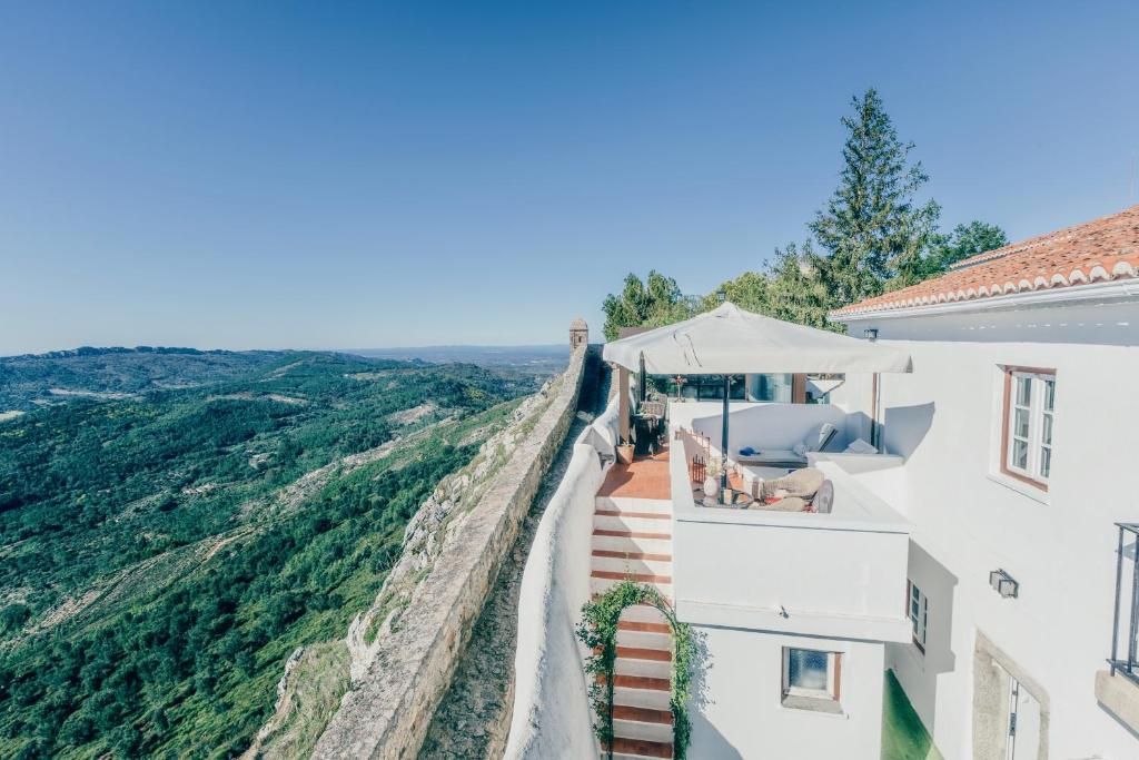 a view from the side of a white building with a view of the mountains at Dom Dinis Marvão in Marvão