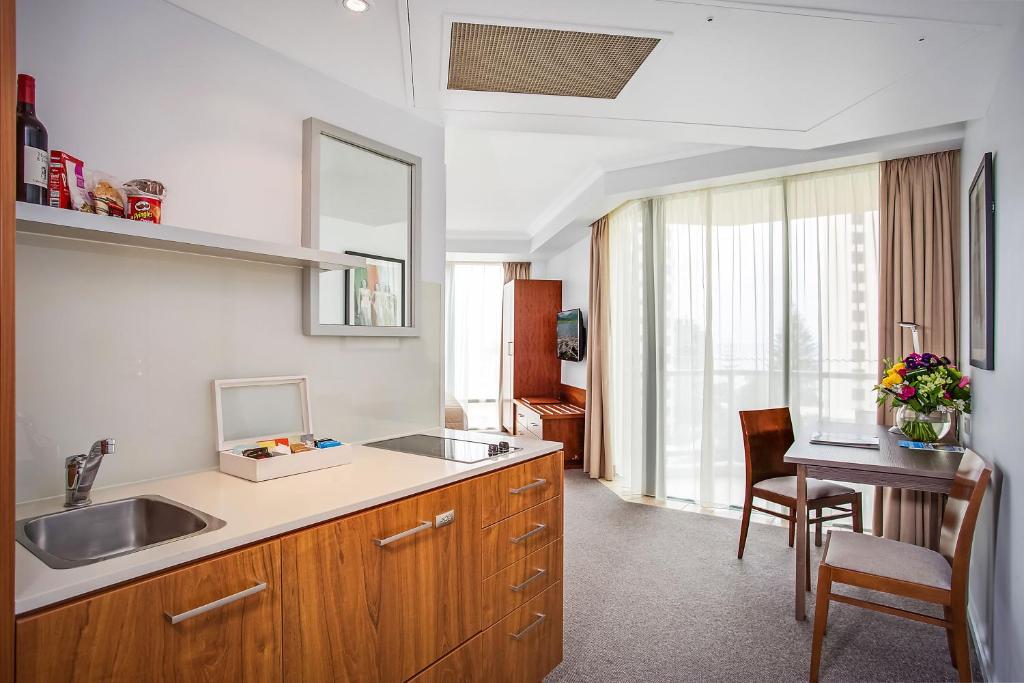a kitchen with a sink and a table at Mantra Legends Hotel in Gold Coast