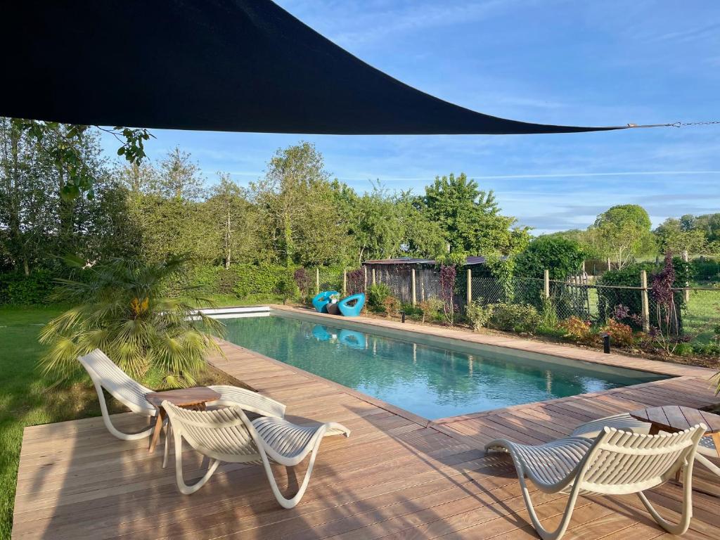 a patio with two chairs and a swimming pool at Chez Mémé Delphine in Moutier-Malcard