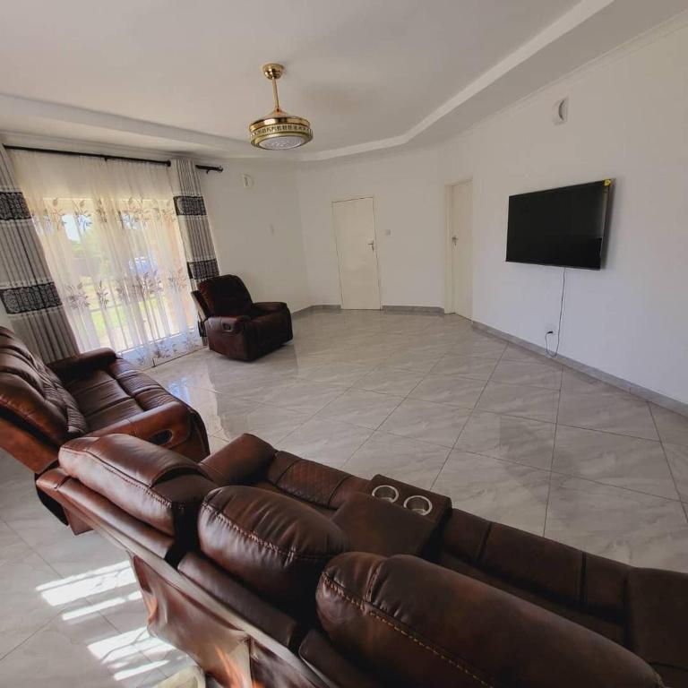 a living room with a couch and a flat screen tv at Familyfriendlyhome4u in Bulawayo