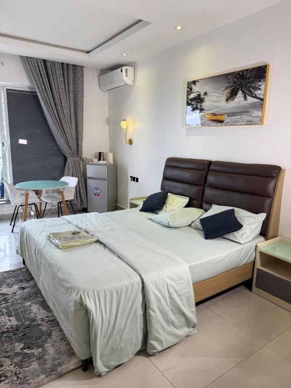a bedroom with a large bed and a table at Precious Pavilion - Single Rooms in Abuja