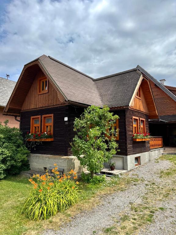 a wooden house with flowers in front of it at Drevenica MATAJKA in Kvačany