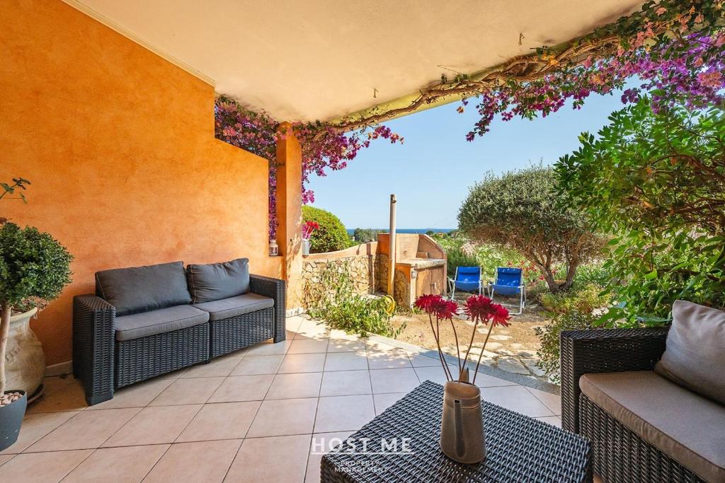 a patio with a couch and a table with flowers at Terrazza 12 - Free Wifi in Costa Rei