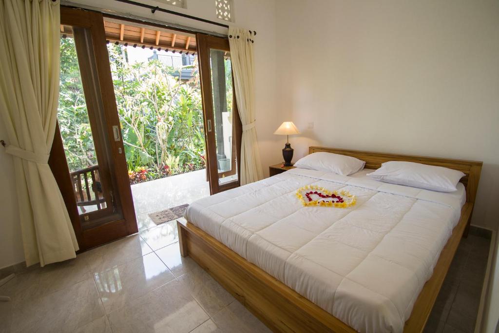 a bedroom with a large bed with a large window at Pangkung Sari in Ubud
