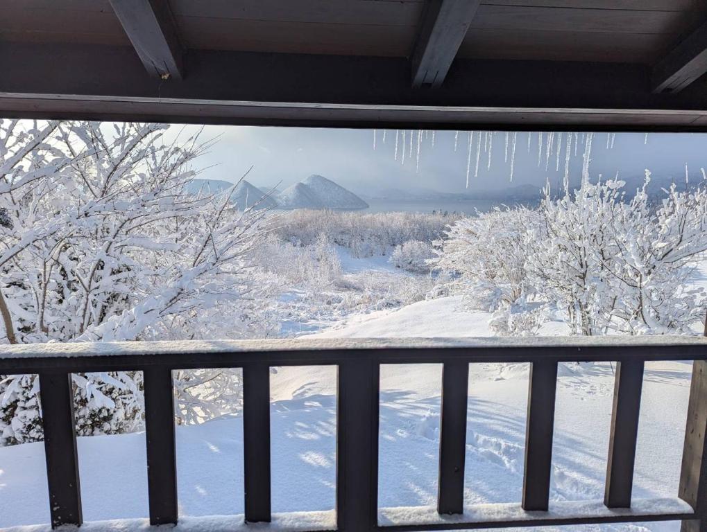 a view from a balcony of snow covered trees at Lakeview Etsu in Lake Toya