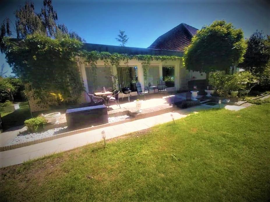 a backyard of a house with a patio and a lawn at Monteurzimmer Grüner Winkel in Lembruch