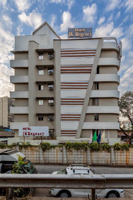 a white building with a sign on top of it at Hotel JK Regency, Mumbai International in Mumbai