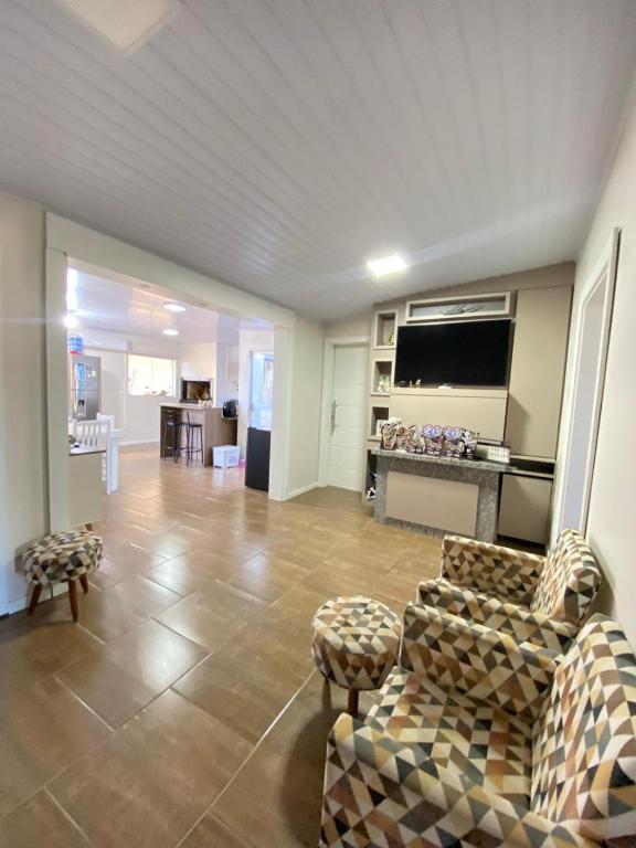 a large living room with couches and a tv at Casa central in Rosário do Sul