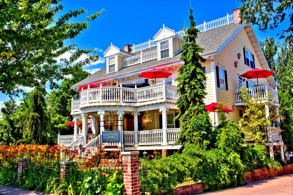 a large white house with red umbrellas at Big Yellow Inn in Cedar City