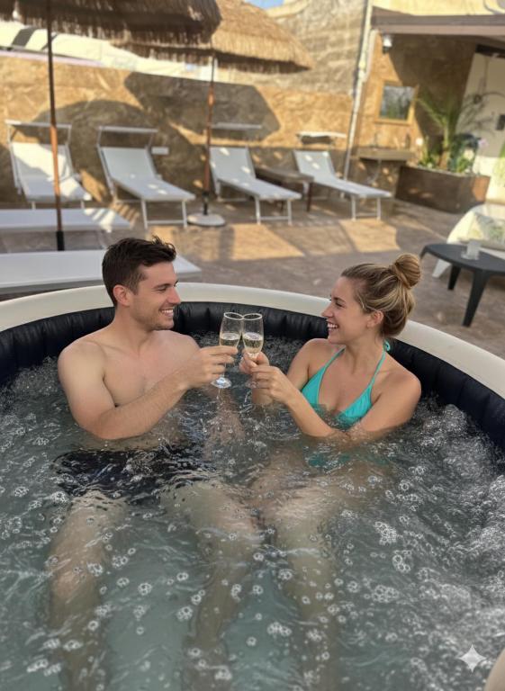 a man and woman drinking wine in a swimming pool at "LE CAMERE" Luxury Rooms SIRACUSA in Syracuse