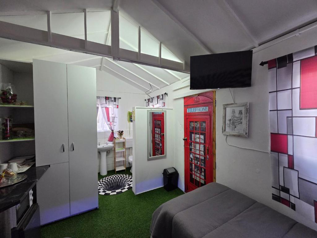 a room with a bed and two red doors at Klaas Vakie Guesthouse in Beaufort West