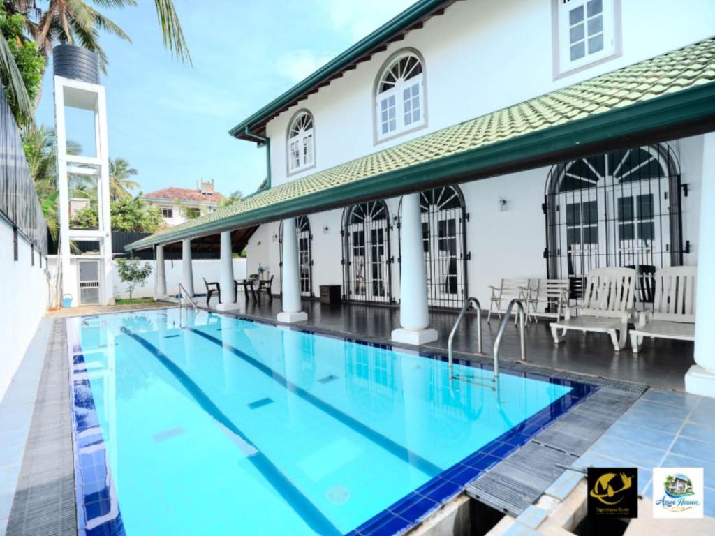 a swimming pool in front of a house at Azure Heaven Villa in Wennappuwa