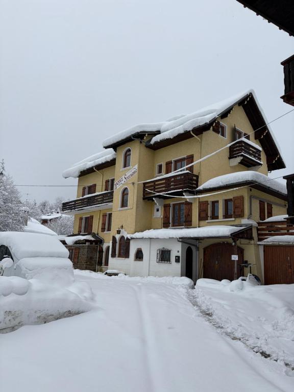 a snow covered street in front of a house at Chalet Hotel Sylvana in Megève