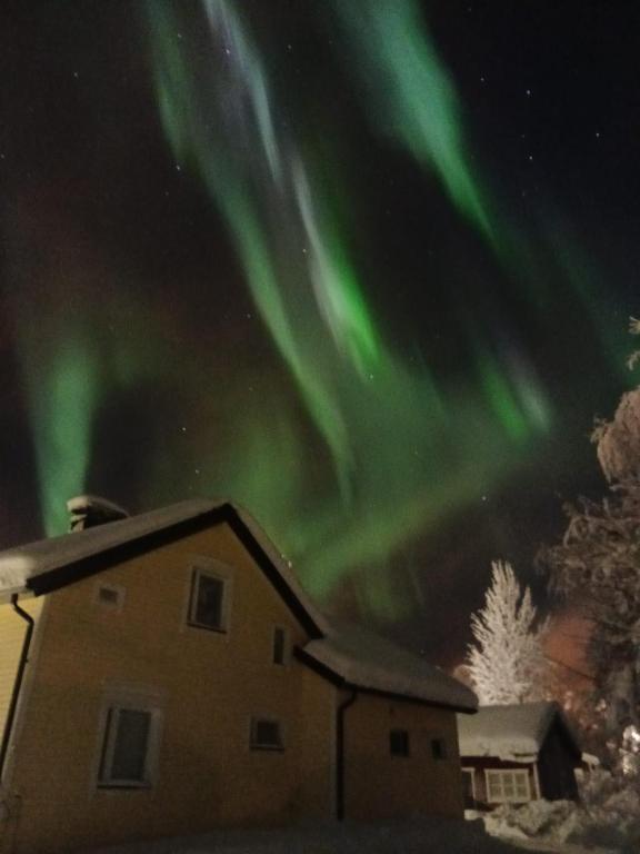 an image of a house with the aurora in the sky at Villa Mutkala in Kittilä