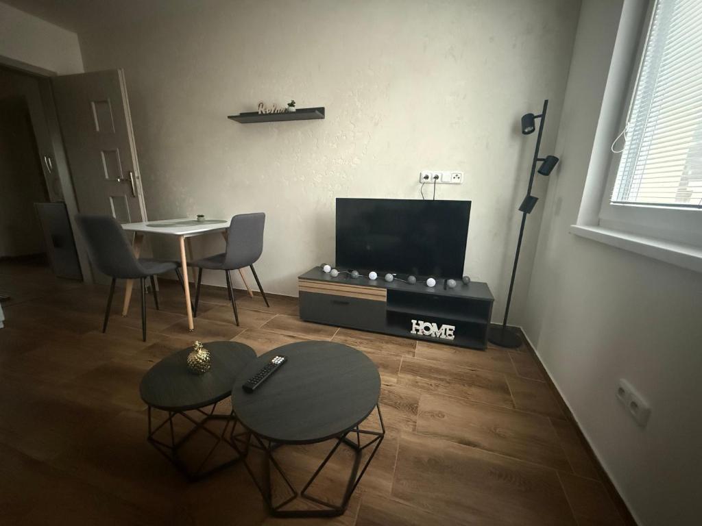 a living room with a tv and a table and chairs at Apartmán LUNA Choceň in Choceň