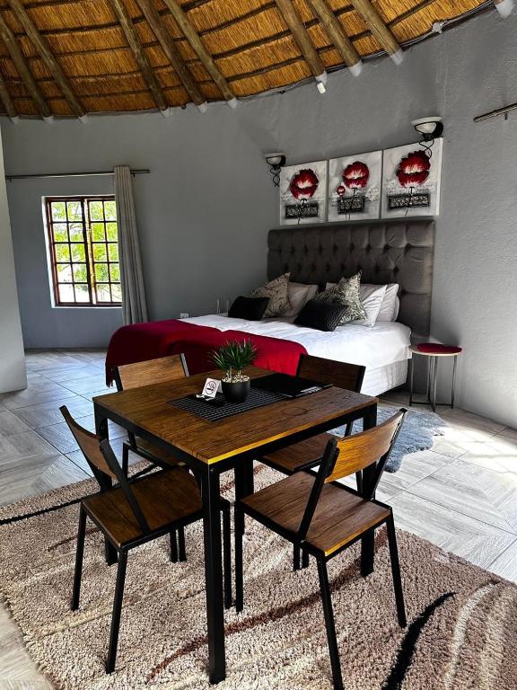 a room with a table and chairs and a bed at Banabaka spa and venue in White River