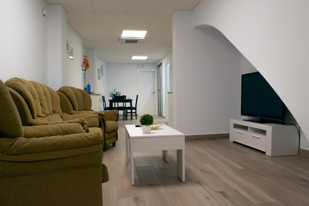 a living room with a couch and a tv and a table at Suites TDJ Centro in Torredonjimeno