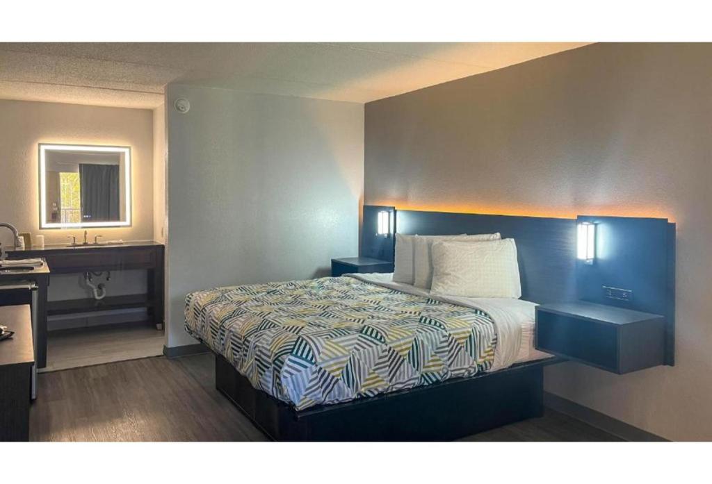 a hotel room with a bed and a sink at Studio 6 Spindale, NC Forest City in Spindale