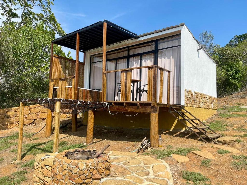 a tiny house on logs with a fire pit at Glamping Barichara in Barichara