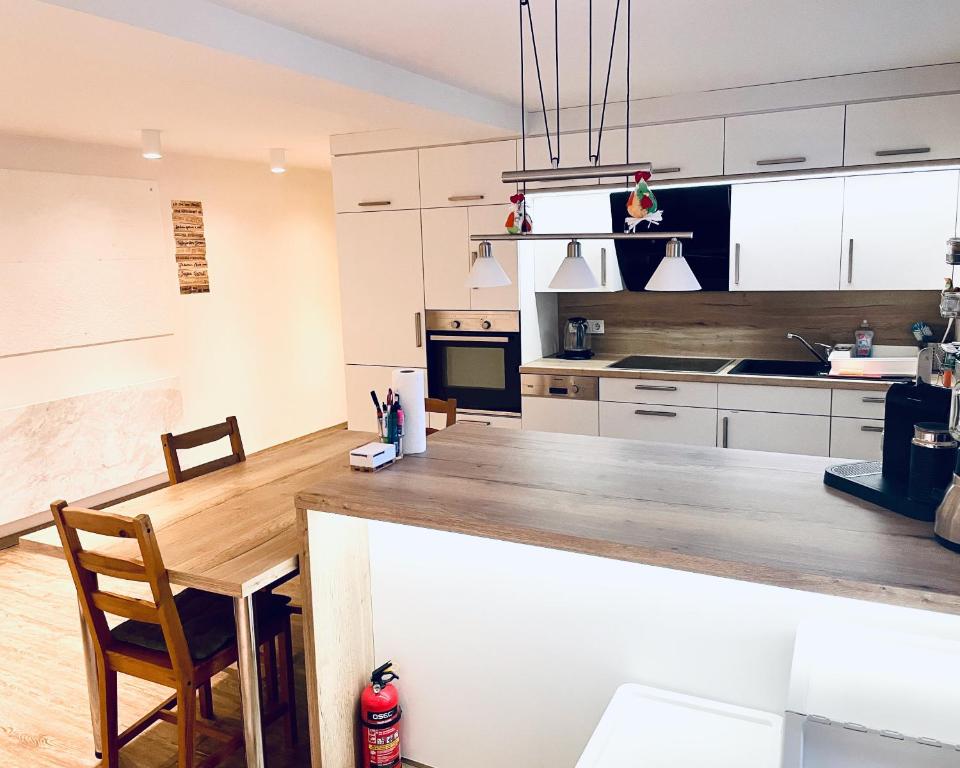 a kitchen with white cabinets and a wooden table at OM Moderne Wohnung, WLAN, Küche, Bad in Stadtilm in Stadtilm