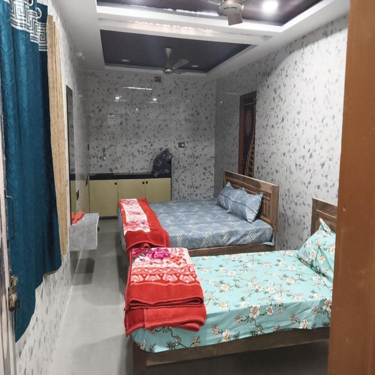 a bedroom with two beds in a room at Tunga sadan in Mādhavaram
