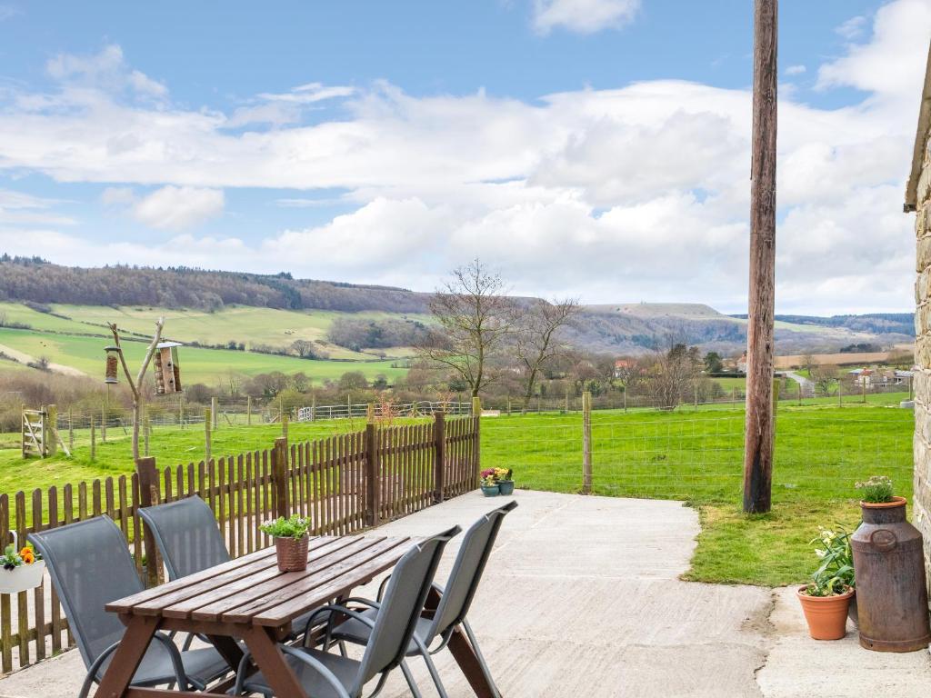 a patio with a wooden table and chairs at Foxglove - Uk51200 in Staintondale