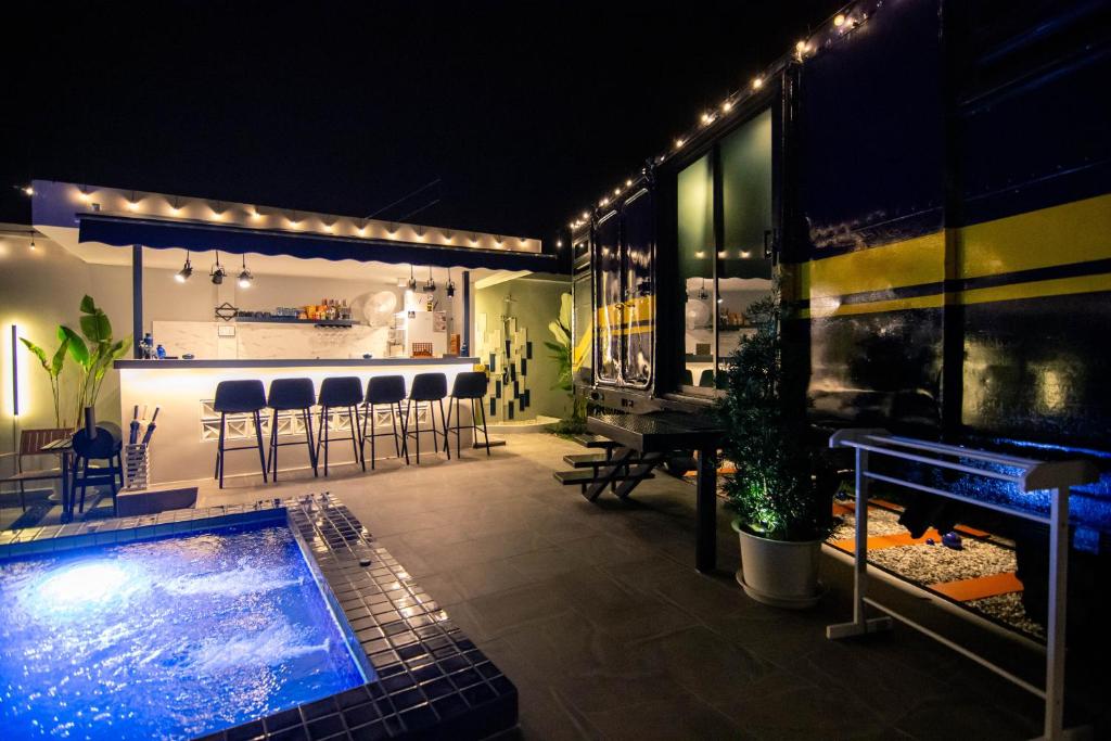a patio with a swimming pool and a bar at Baan Rot Fai Krabi Platform 3 in Ao Nam Mao