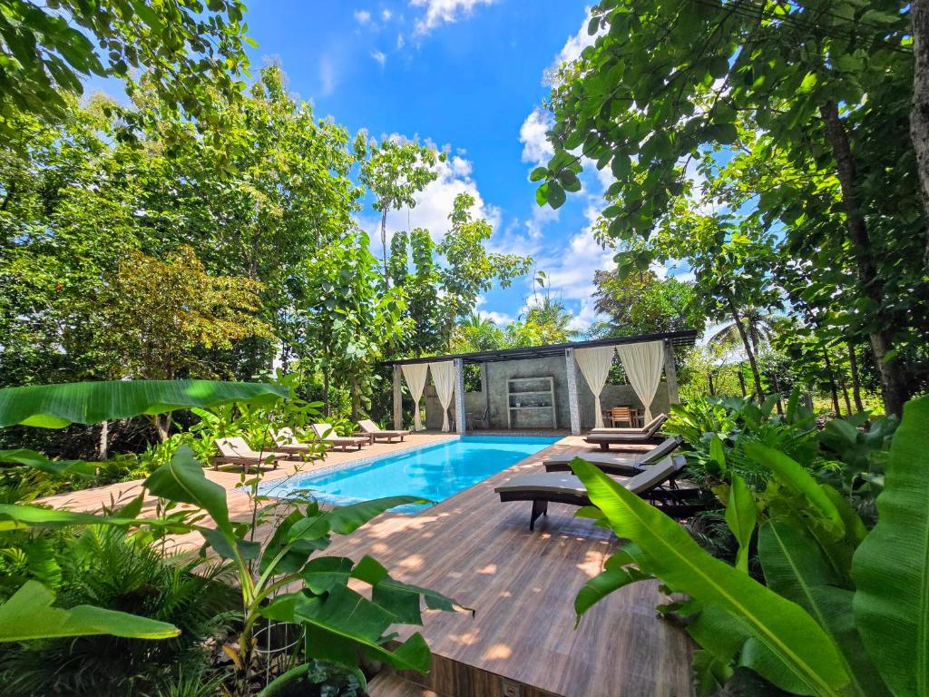 a swimming pool with chaise lounges on a wooden deck at Anusorn Villas & Garden Oasis - Peaceful Chiang Mai Hideaway in Ban Ton Chok