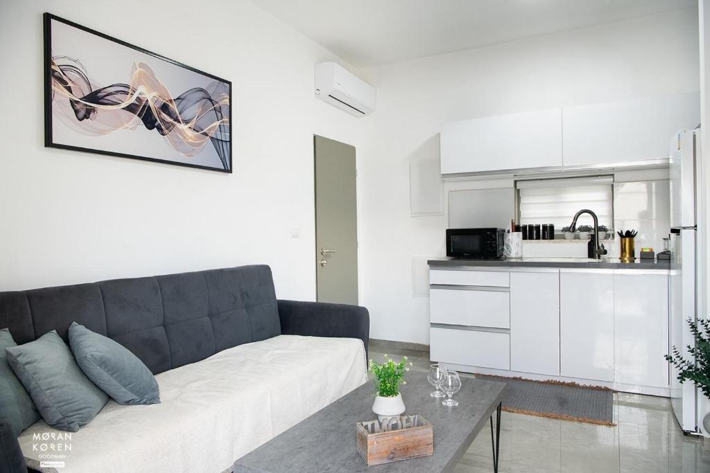 a living room with a couch and a kitchen at פסגת יובלים 2 in Qiryat Shemona