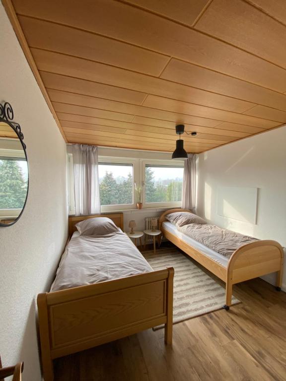 two beds in a room with two windows at 3-Zimmer-Ferienwohnung in Werl