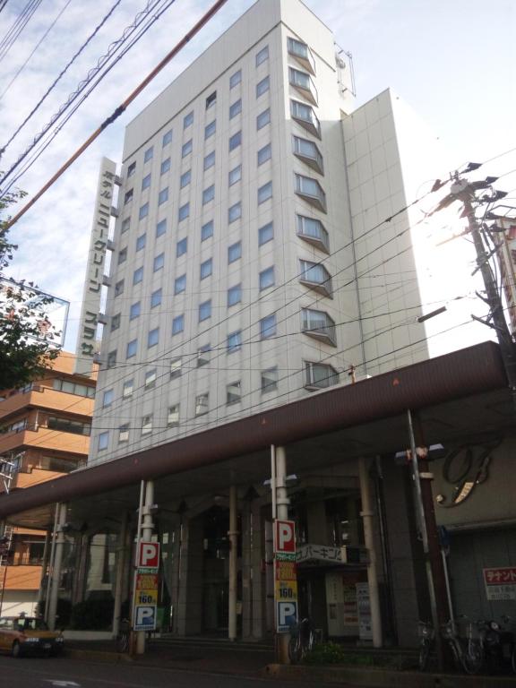 a large white building on the corner of a street at Hotel New Green Plaza in Nagaoka