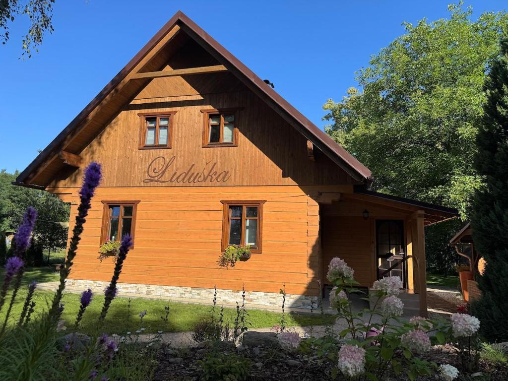 a log house with a sign on the side of it at Roubenka Liduška in Mikulovice