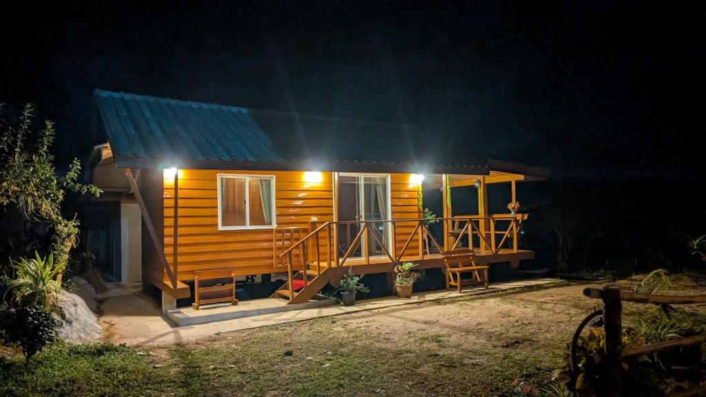 a small wooden house with a porch at night at Slow Home in Ban Yang Mae Luang