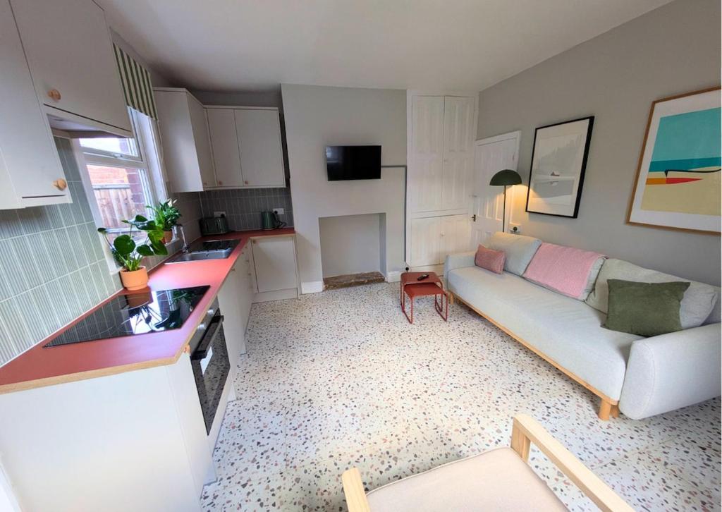a living room with a couch and a kitchen at Tranquil flat in vibrant Nether Edge in Nether Edge