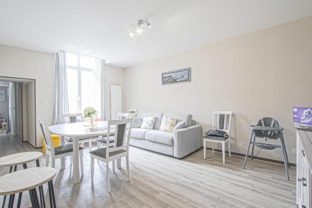 a living room with a couch and a table and chairs at Le nid Saint Jean apartment in the heart of the city in Bayeux