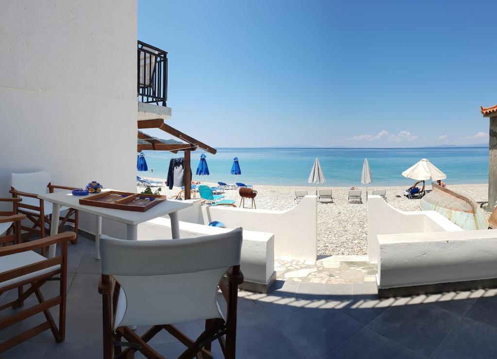 a view of a beach with chairs and a table at Beachfront villa Ioanna in Kokkari