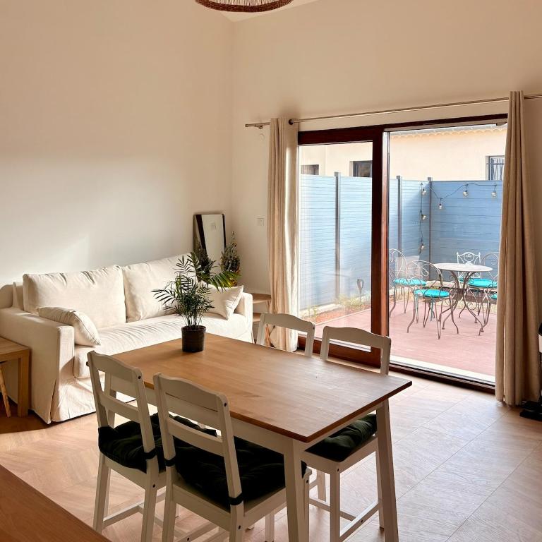 a living room with a wooden table and chairs at Esprit Lubéron, Le Romarin, logement entier in Le Thor