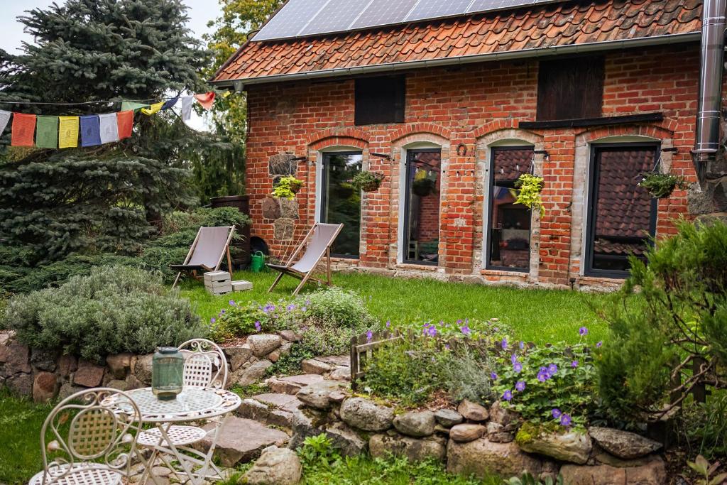 a brick house with a table and chairs in a garden at Feel-Harmonia w Nowym Kawkowie in Nowe Kawkowo