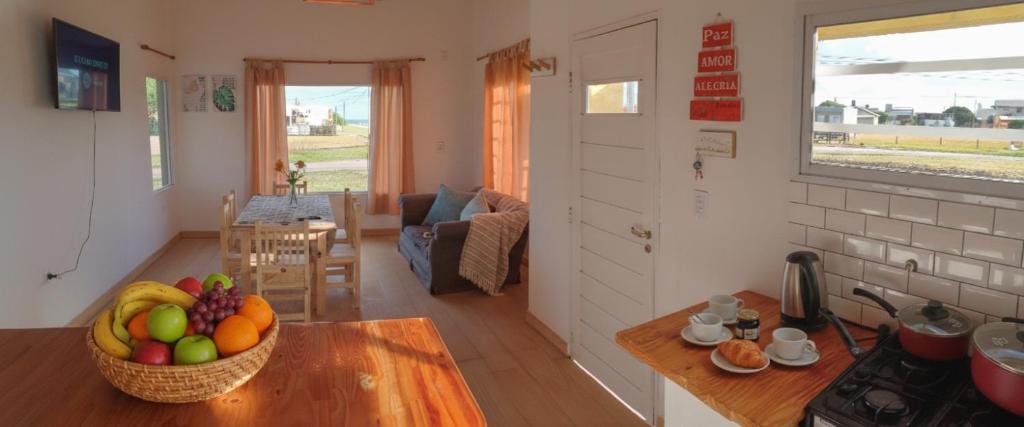 a kitchen and living room with a bowl of fruit on a table at Santa Relax in Frente Mar