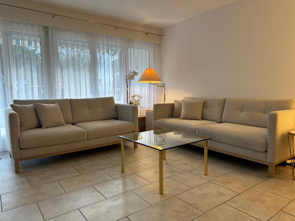 a living room with two couches and a coffee table at Garden Park Apartment in Interlaken
