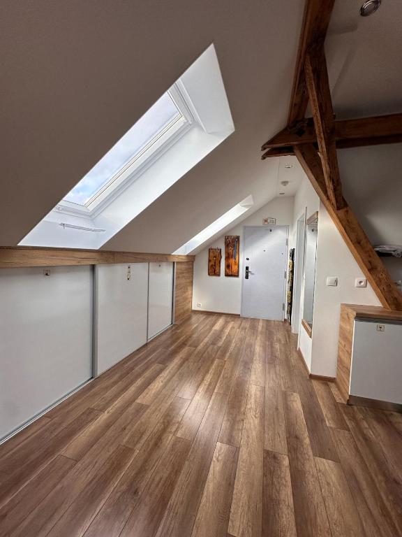 an attic room with a skylight and wooden floors at PS5, VR2, Logitech racing-Apartmán pod Chočom in Leštiny