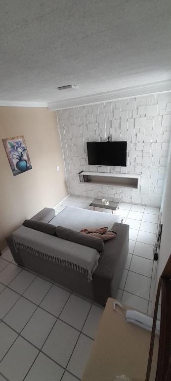 a bedroom with a bed and a white brick wall at Ap no Turu, 10 min das praias in São Luís