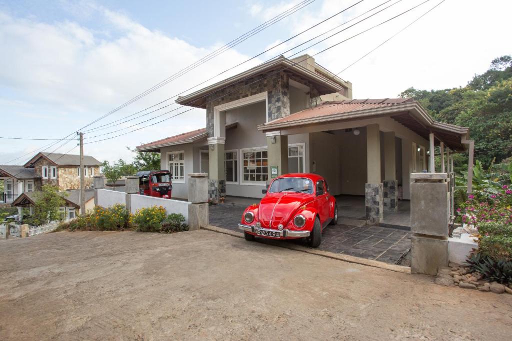 a red car parked in front of a house at Vista House Kandy in Kandy